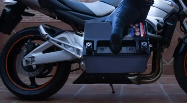 Rękawiczka zakłada nowy akumulator do motocykla. Zastanawiasz się, jaki akumulator do motocykla będzie najlepszy?