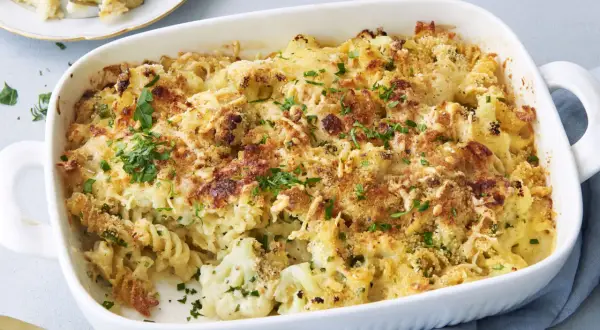 Ein goldbrauner Blumenkohl Auflauf mit Nudeln und knuspriger Käsekruste, garniert mit frischer Petersilie.