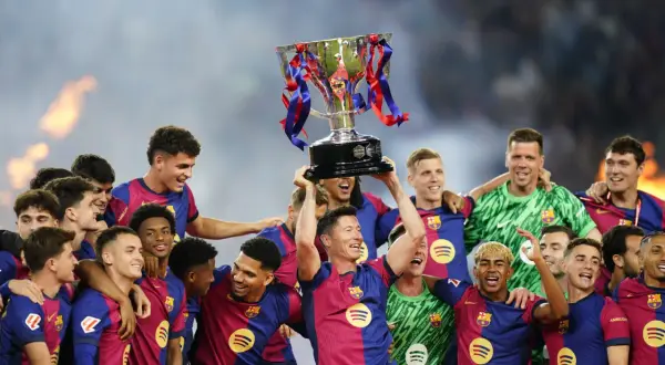 Piłkarze świętują zdobycie pucharu La Liga, wznosząc go nad głowami.
