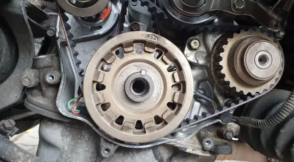 Widok na mechanizm napędu rozrządu silnika. Widać koła zębate, napinacz i pasek. Czas na wymianę rozrządu!