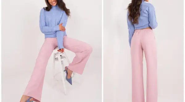 Modelka w swetrze i szerokich spodniach w kolorze brudny róż. Elegancka stylizacja na co dzień.