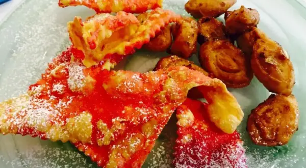Dolci di carnevale marchigiani: chiacchiere rosse e frittelle dorate, cosparse di zucchero a velo, un piacere per gli occhi e il palato.