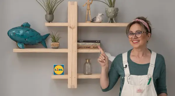 Estantería DIY de madera con pez decorativo, plantas y libros. Una mujer sonríe y señala la estantería.
