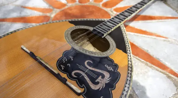 Piękny grecki instrument muzyczny, bouzouki, leży na mozaice w kształcie słońca.