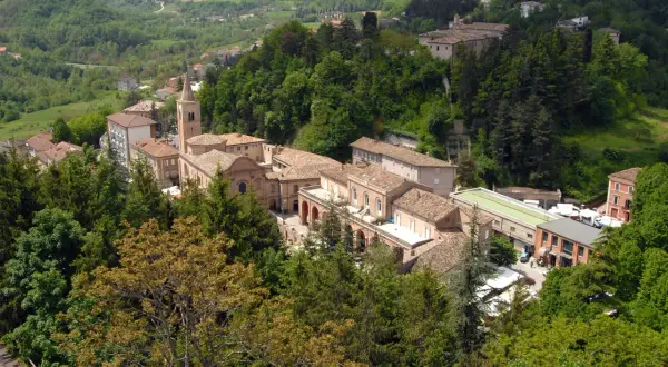 Borgo collinare con edifici in pietra e tetti in tegole, circondato da boschi rigogliosi. Un luogo incantevole da amandola cosa vedere.