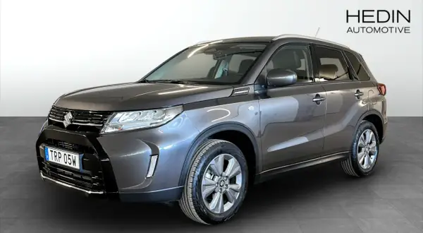 En mörkgrå Suzuki Vitara Hybrid står redo för en provkörning. Denna bil är perfekt för dig som söker en pålitlig och bränslesnål SUV.