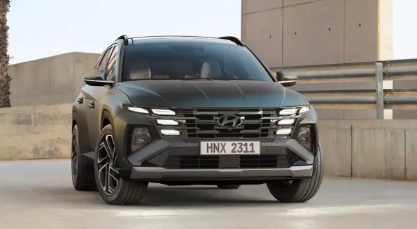 Hyundai Tucson hybrid test. En mörkgrön SUV med distinkta LED-lampor och en modern grill.