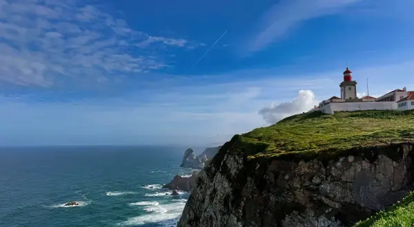 Majestatyczny **Cabo da Roca** z latarnią morską na szczycie klifu, gdzie ocean spotyka ląd.