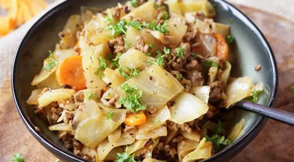 Herzhaftes Gericht aus spitzkohl mit hackfleisch und kartoffeln, garniert mit Petersilie.