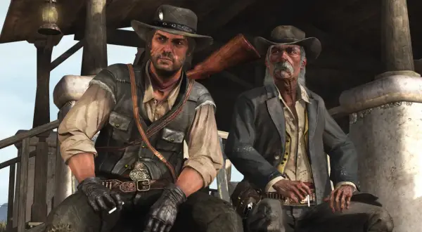 Dwóch kowbojów, jeden młodszy, drugi starszy, siedzi pod wiatą. Scena z gry Red Dead Redemption 2 PC.