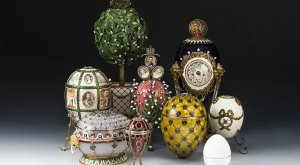 Una collezione di uova Fabergé, ognuna con un significato unico, esposte con dettagli preziosi e miniature.