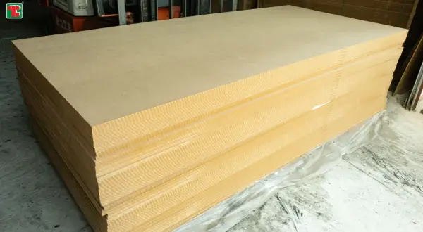 Pile de panneaux de contreplaqué ou aggloméré, prêts à être utilisés pour des projets de construction ou de décoration.