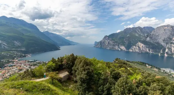 Panoramica mozzafiato del Lago di Garda, ideale per **leichte wanderungen am Gardasee**. Montagne verdi e rocciose incorniciano il blu intenso dell'acqua.
