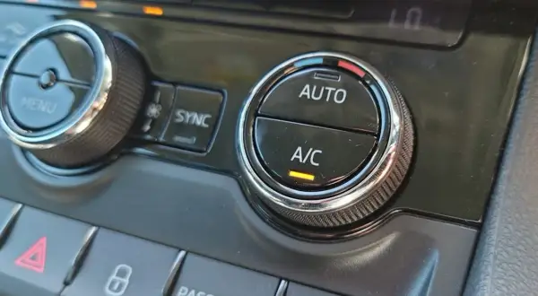 Klimatanläggningens reglage i bilen. A/C-knappen lyser, redo att bekämpa imma i bilen.