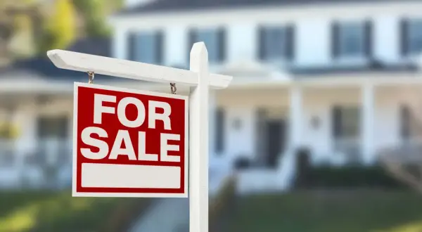 Cartello "For Sale" davanti a una casa. Si può vendere un immobile senza successione, una nuova opportunità per chi cerca casa.