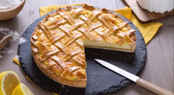 Délicieux dessert ricotta citron, une tarte dorée à la garniture crémeuse, prête à être dégustée.