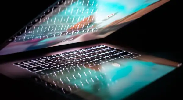 Podświetlana klawiatura laptopa odbija się w ekranie, tworząc efekt 287 kk.