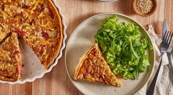Tarta de atún dorada, servida con ensalada fresca. Un plato perfecto para disfrutar.
