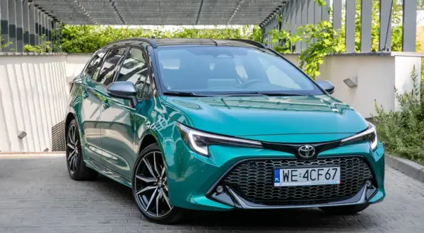 Zielona Toyota Corolla kombi z czarnym dachem, prezentująca swoje dynamiczne linie. Idealna do miasta i na dalsze trasy, jej toyota corolla wymiary zapewniają komfort.