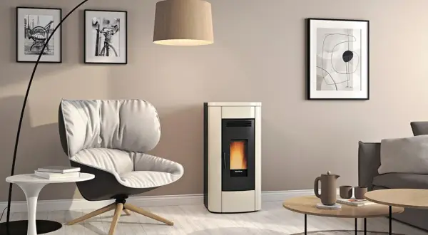 Gemütliches Wohnzimmer mit modernem Pellet-Kaminofen, dessen Flammen hinter Glas tanzen. Die schlichte tapete hinter kaminofen unterstreicht das Design.