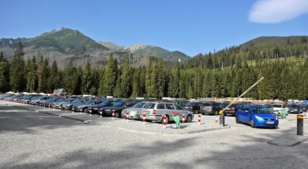 Parking pod Tatrami, tuż przed szlakiem na Morskie Oko. Samochody czekają na turystów.