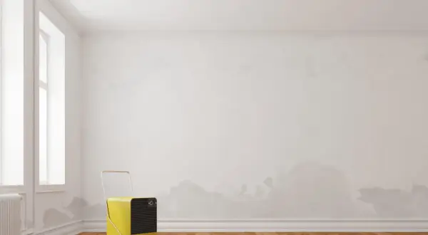 Gelber Luftentfeuchter bekämpft Feuchtigkeit aus Wand ziehen hausmittel. Flecken an der Wand deuten auf Probleme hin.
