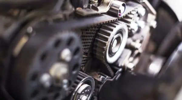 Detaljerad bild av en motor med kamrem, troligen för ett Renault Megane kamremsbyte.