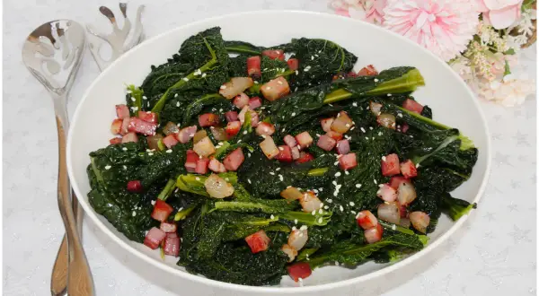 Cavolo nero in padella senza bollire, saltato con cubetti di pancetta croccante e semi di sesamo. Un contorno saporito e veloce.