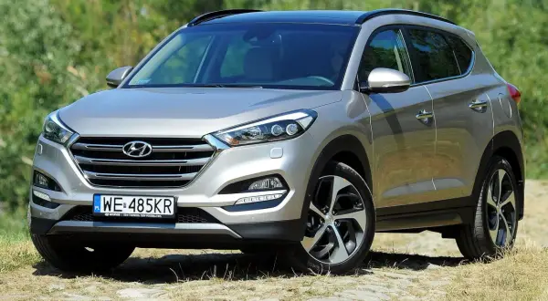 Srebrny Hyundai Tucson na tle zieleni. Zastanawiasz się, jaki silnik wybrać do swojego Tucsona?