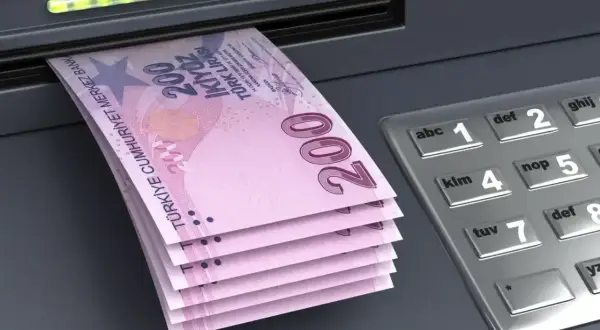 Banknoty liry tureckiej wychodzące z bankomatu. Pytanie, czy w Turcji można płacić euro, jest częste, ale lokalna waluta jest tu podstawą.
