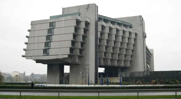 Monumentalny budynek w stylu brutalizm, z betonową fasadą i charakterystycznymi, wystającymi elementami.