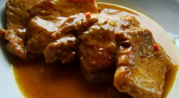 Soczysta szynka pieczona w plastrach, polana aromatycznym sosem, idealna na obiad.