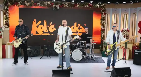Zespół Kolaboranci, w tym Andrzej Kobra Kraiński, gra na scenie z świątecznymi dekoracjami.