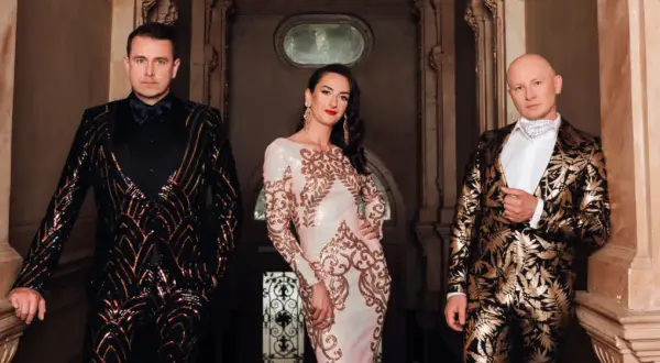 Kabaret K2 skład: mężczyzna w błyszczącej marynarce, kobieta w sukni z cekinami i mężczyzna w złotej marynarce.