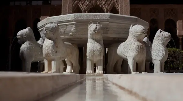 La fuente de los leones en la Alhambra, con sus esculturas de mármol que vierten agua, es un símbolo de la belleza nazarí.