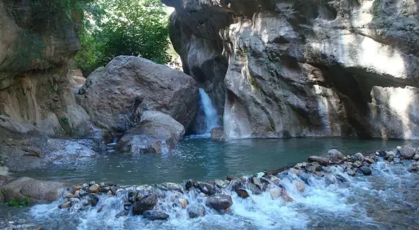 Un rincón idílico en las cascadas de Padules, Almería, donde el agua cristalina fluye entre rocas y vegetación exuberante.