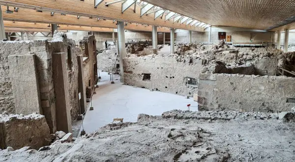 Ruiny Akrotiri pod nowoczesnym dachem. Kamienne mury i ślady dawnego życia na Santorini.