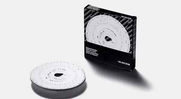 Un chronotachygraphe analogique, avec sa boîte et un disque de diagramme, prêt à enregistrer les trajets des véhicules.