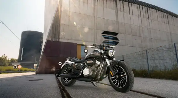 Czarny motocykl typu chopper 125 na tle nowoczesnego budynku.