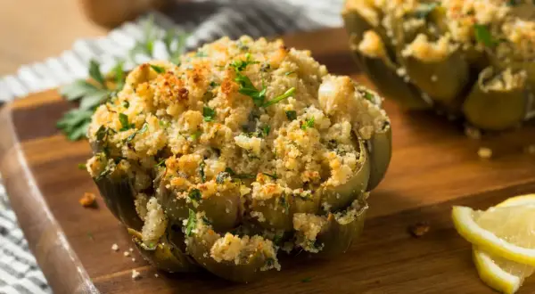 Carciofi ripieni e dorati, cotti alla perfezione nella friggitrice ad aria, guarniti con prezzemolo fresco e spicchi di limone.