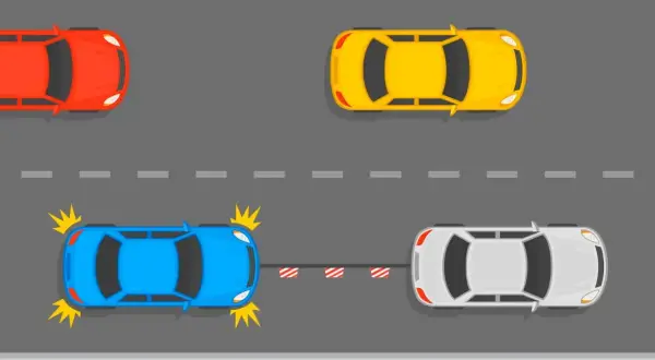 Niebieski samochód z uszkodzeniami jest holowany przez biały. Czy można holować auto bez przeglądu? Czerwony i żółty samochód jadą dalej.