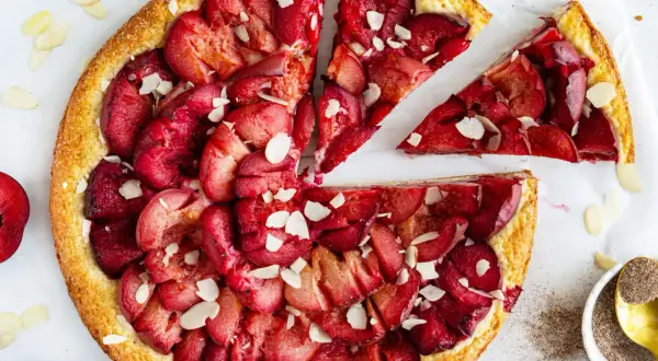 Ein schneller Pflaumenkuchen mit Quark, belegt mit saftigen Pflaumen und Mandelsplittern. Perfekt für den Kaffeetisch!