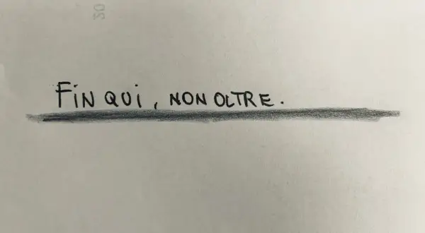 Fin qui, non oltre." Una frase scritta a mano su carta, che suggerisce come farsi rispettare in amore, ponendo dei limiti chiari.