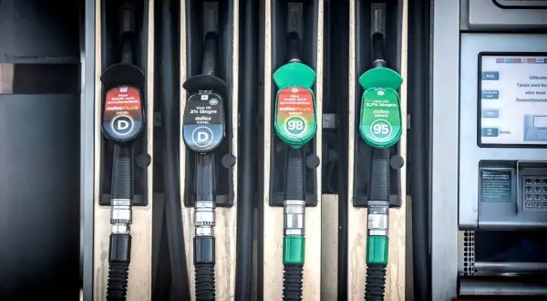 Fyra pumpar vid en bensinstation, två för diesel och två för bensin. En av dieselslangarna har en etikett som varnar för alger i dieseltank.