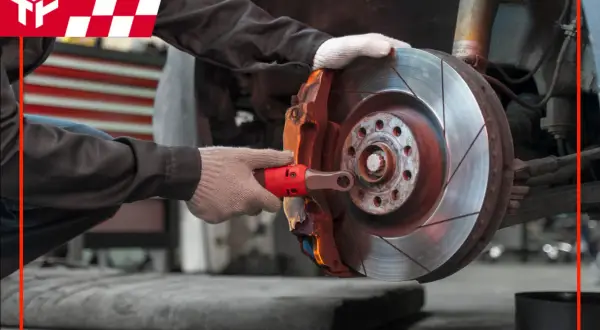 Mechanik sprawdza tarczę hamulcową, upewniając się, że jej **minimalna grubość tarczy hamulcowej** jest zachowana dla bezpieczeństwa.