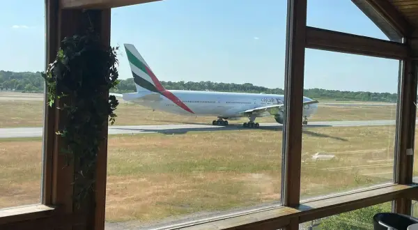 Ein Emirates-Flugzeug rollt auf dem Rollfeld. Perfekt für ein "Cafe to fly" mit Aussicht.