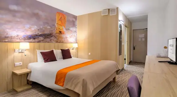 Pokój hotelowy z łóżkiem, tapetą z bursztynem i widokiem na morze, idealny na pobyt w Posejdon Gdańsk.
