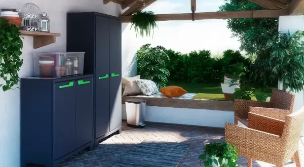 Ciemnoszara szafka na balkon z zielonymi uchwytami, idealna do przechowywania narzędzi ogrodowych i doniczek.