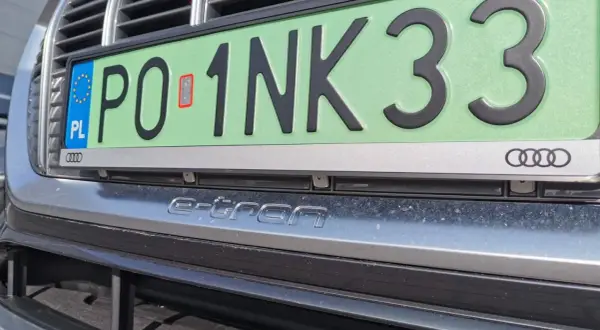 Zielone tablice rejestracyjne z napisem "e-tron" na zderzaku Audi.