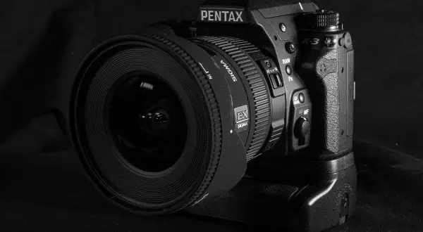 Czarno-białe zdjęcie lustrzanki Pentax K-3 z obiektywem Sigma.
